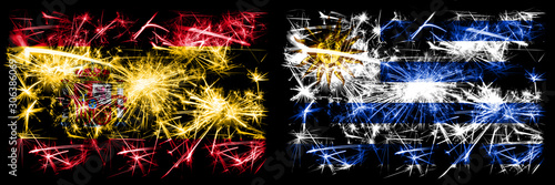 Spanish vs Uruguay, Uruguayan New Year celebration sparkling fireworks flags concept background. Combination of two abstract states flags. © Vlad
