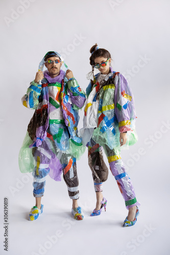 Woman and man wearing plastic on white background. Models in clothes and shoes made of garbage. Fashion  style  recycling  eco and environmental concept. Too much pollution  we re eating and taking it