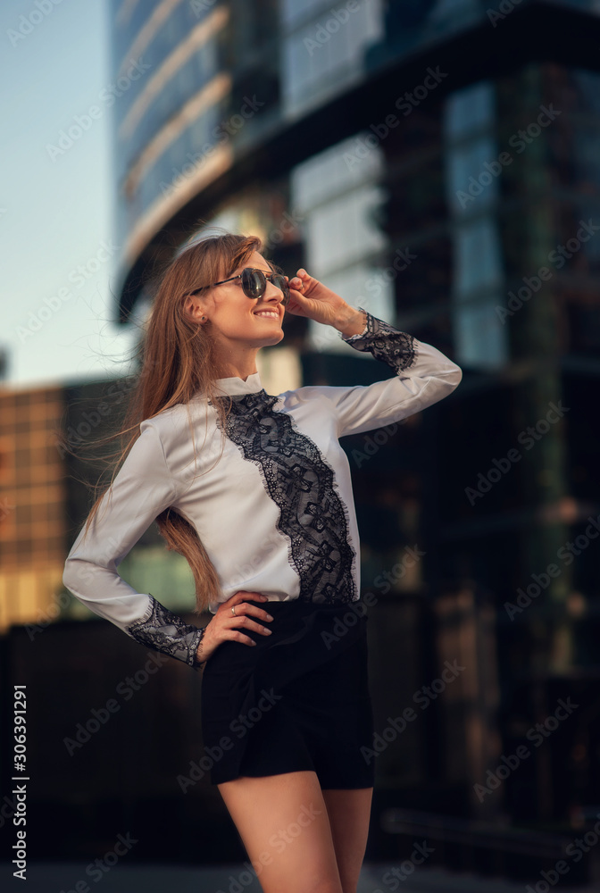 Fototapeta premium Summer portrait of a beautiful girl with long hair on the background of Moscow City