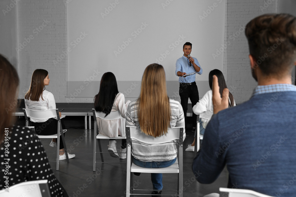 Male business trainer giving lecture in conference room with projection screen Male business trainer giving lecture in conference room with projection screen