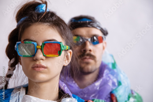 Woman and man wearing plastic on white background. Models in clothes and shoes made of garbage. Fashion  style  recycling  eco and environmental concept. Too much pollution  we re eating and taking it