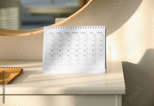 Paper calendar on white chest of drawers indoors photo