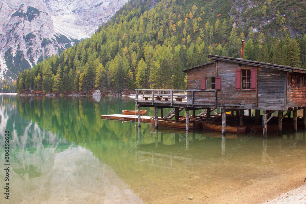 Fototapeta premium Beautiful lake Brais in the Italian Dolomites with reflection of the sky and boats on the surface