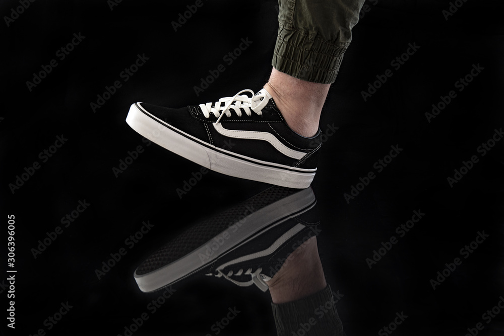 Young man wearing brand new black and white Vans Old Skool shoes foto de  Stock | Adobe Stock