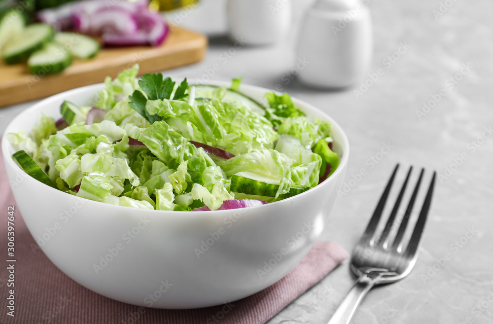 Tasty salad with cabbage and cucumbers on light grey marble table, closeup Tasty salad with cabbage and cucumbers on light grey marble table, closeup