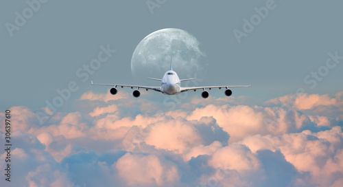 White passenger airplane in the clouds with full moon - Travel by air transport 