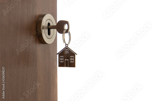 Open door to a new home. Key and home shaped keychain, isolated. Mortgage, investment, real estate, property and new home concept