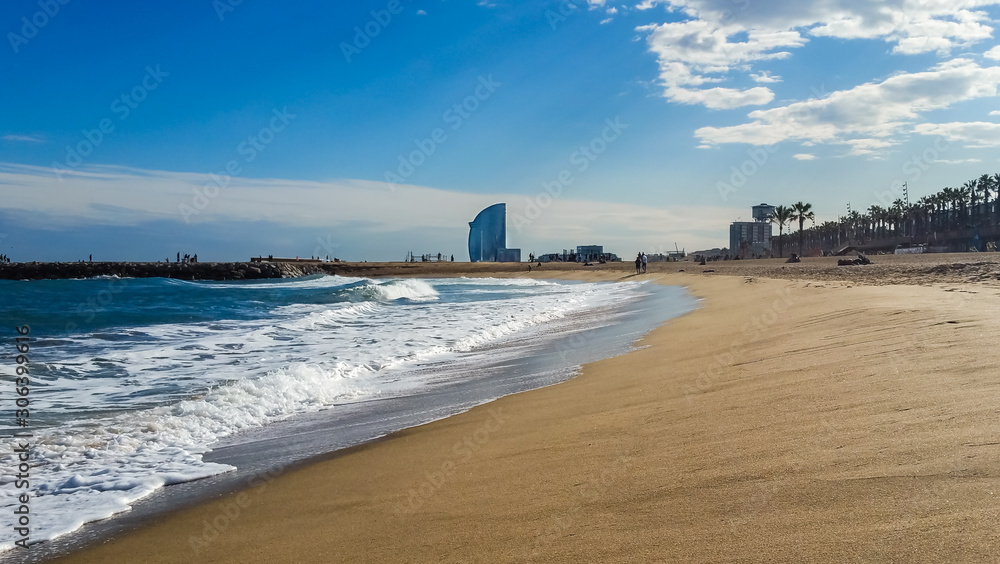 Barcelona, Spain - Iconic luxury W Barcelona hotel view from Barceloneta beach on a sunny day. Striking sail-like structure offering breathtaking design and fantastic views.