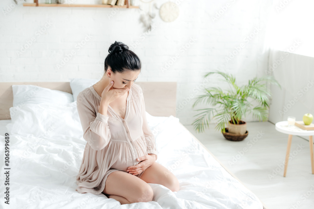 attractive pregnant woman in nightie having nausea in bedroom attractive pregnant woman in nightie having nausea in bedroom