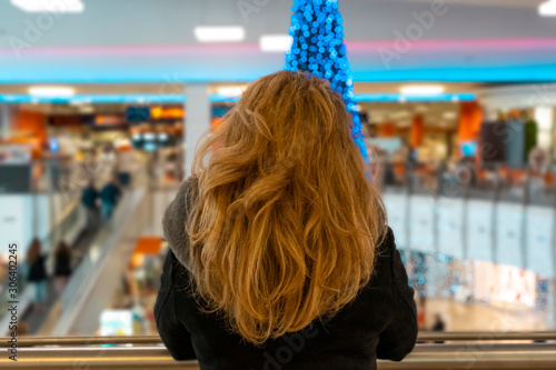 Foto attractive woman looking at a giant Christmas tree