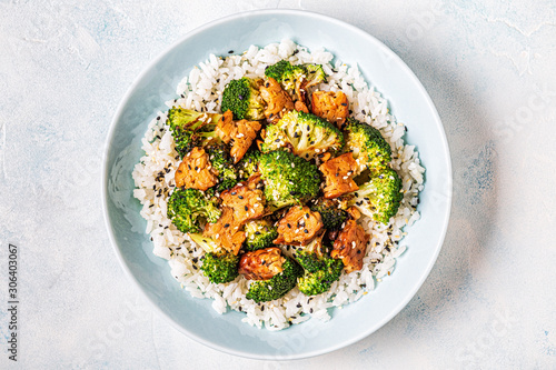 Foto Fried tempeh with rice and broccoli.
