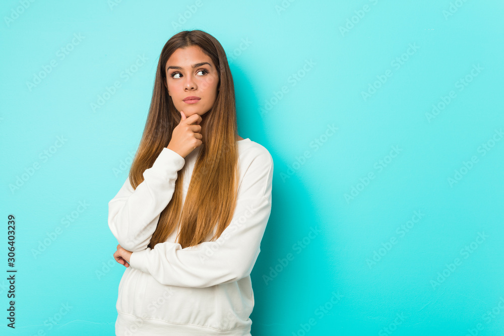 Young slim woman looking sideways with doubtful and skeptical expression. Young slim woman looking sideways with doubtful and skeptical expression.