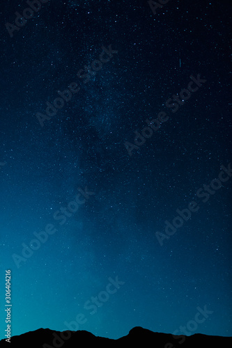 Starscape over mountain tops in cold winter night