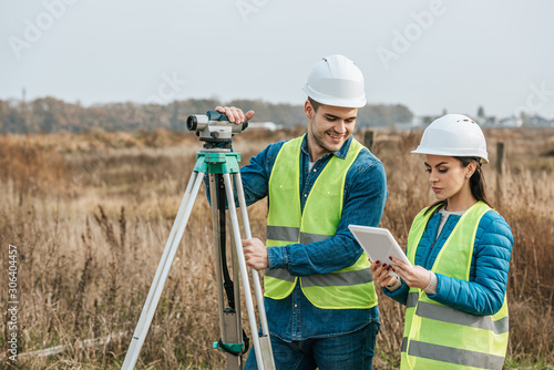 Surveyors working with digital level and tablet in field