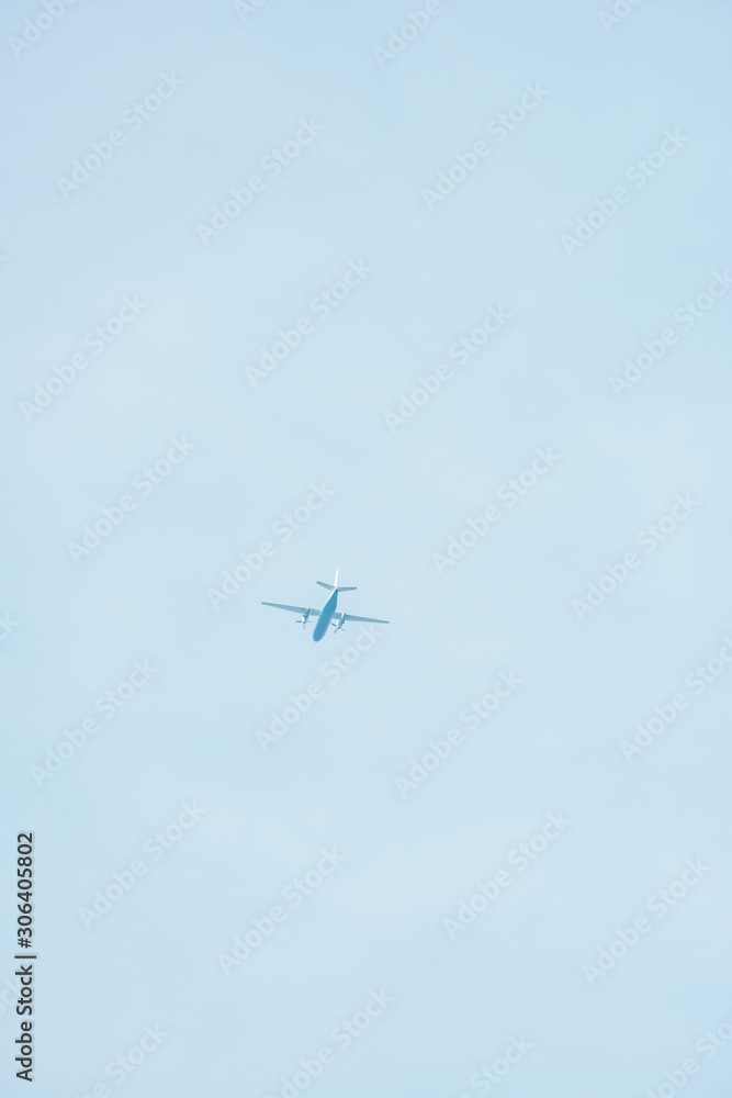 Bottom view of airplane with blue sky at background