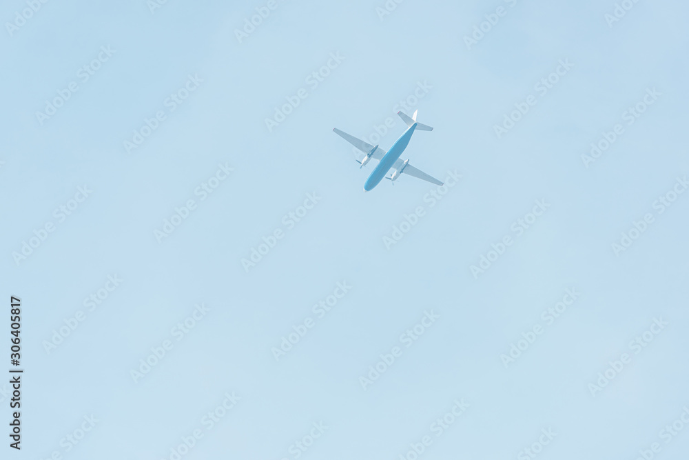 Bottom view of airplane with blue sky at background Bottom view of airplane with blue sky at background