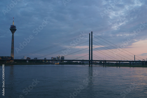 Fantastic bright view of the Rhine banks. Silhouette of the D  sseldorf Rheinkniebr  cke  Rhine Knee bridge  and Rheinturm - television and broadcasting tower.