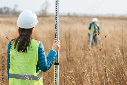 Cuadro en lienzo Selective focus of surveyors with survey ruler and digital level in field