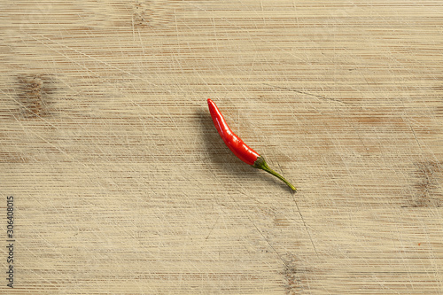 horizontal single red chili pepper from top on the cutboard