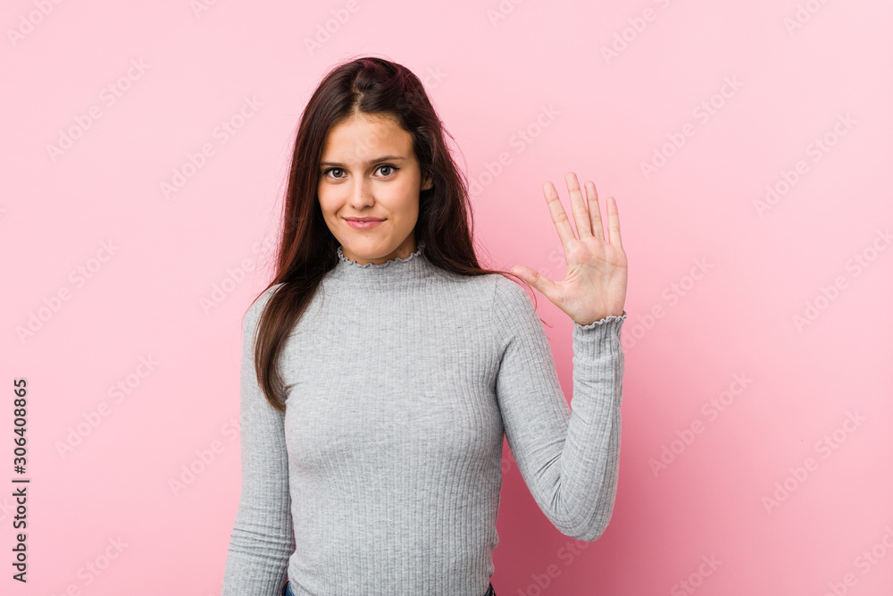 Young cute woman smiling cheerful showing number five with fingers. Young cute woman smiling cheerful showing number five with fingers.