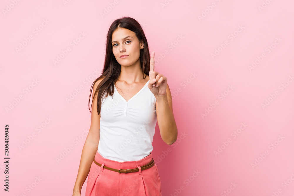 Young cute woman showing number one with finger. Young cute woman showing number one with finger.