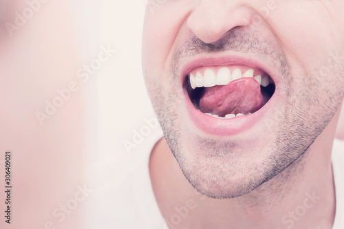 Reflection of a man in the mirror, baring his teeth, close up, toned