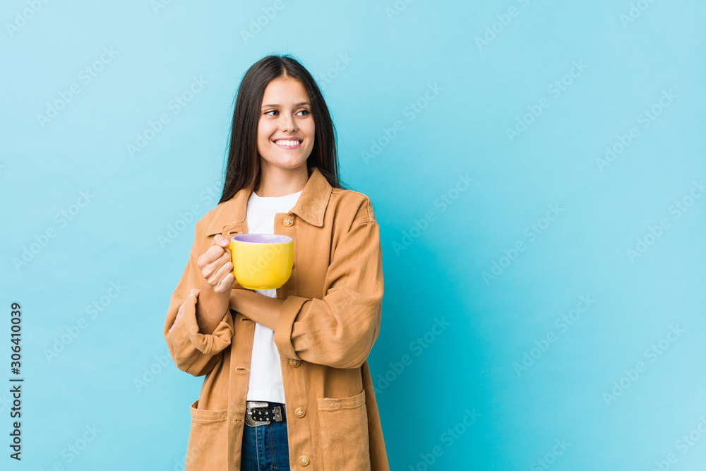 Young caucasian woman holding a coffee mug smiling confident with crossed arms. Young caucasian woman holding a coffee mug smiling confident with crossed arms.