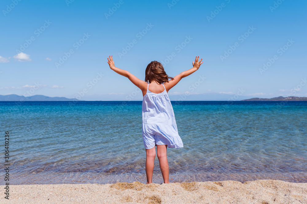 Cute little girl looking at sea on beautiful tropical beach. Summer, fun and vacations concept Cute little girl looking at sea on beautiful tropical beach. Summer, fun and vacations concept