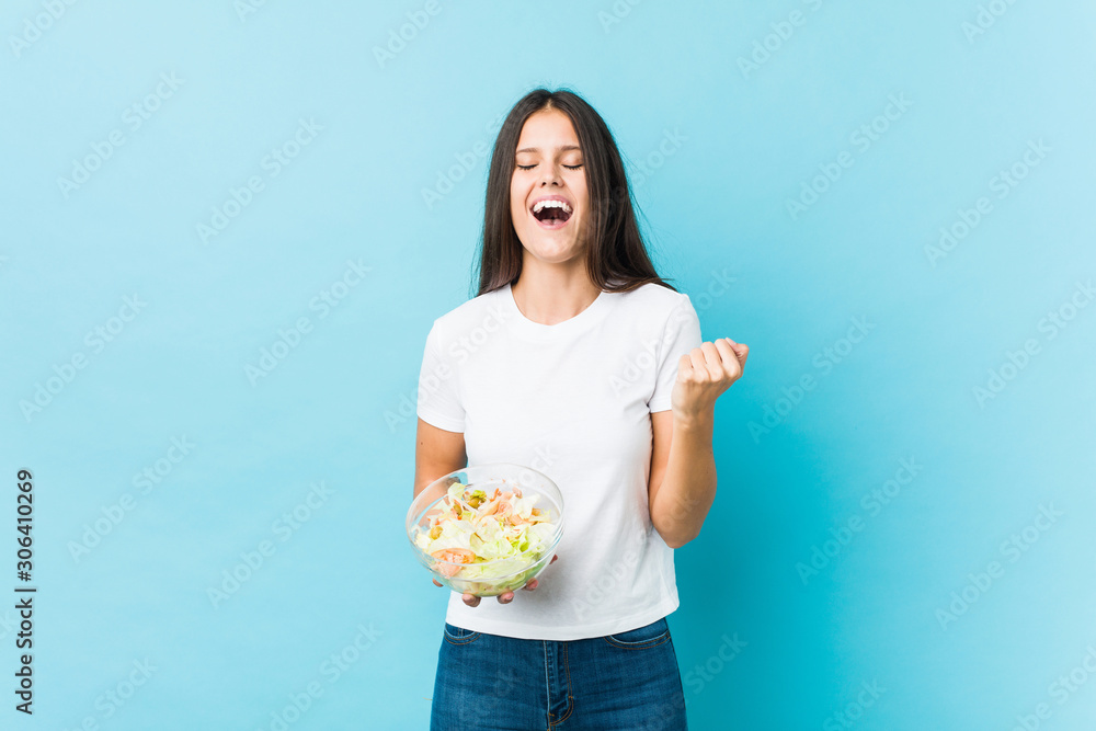 Young caucasian woman holding a salad cheering carefree and excited. Victory concept. Young caucasian woman holding a salad cheering carefree and excited. Victory concept.
