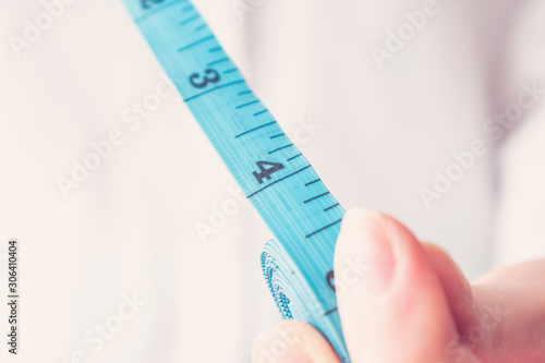 Person with tape measure shows 4 inch length, four inch, closeup, toned