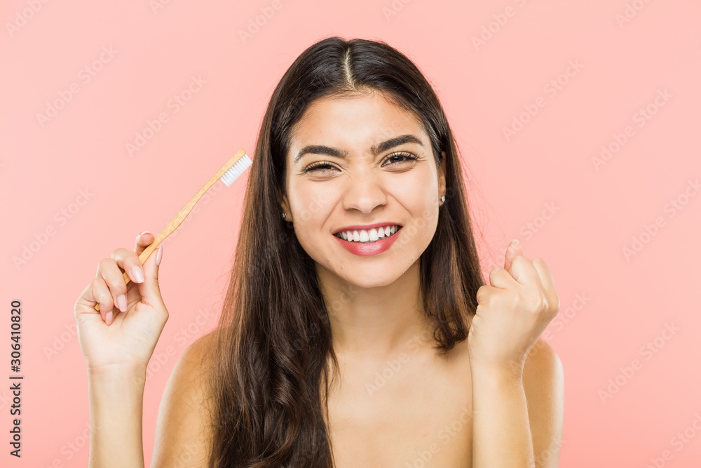 Young indian woman holding a toothbrush cheering carefree and excited. Victory concept. Young indian woman holding a toothbrush cheering carefree and excited. Victory concept.