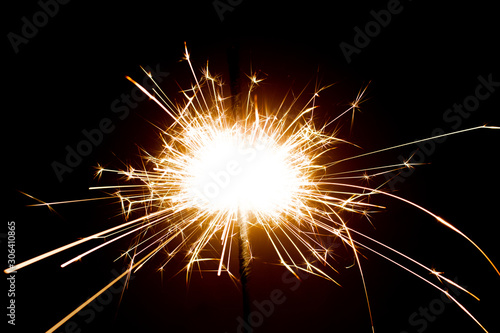 Sparkler in honor of the holiday on a black background. Merry Christmas