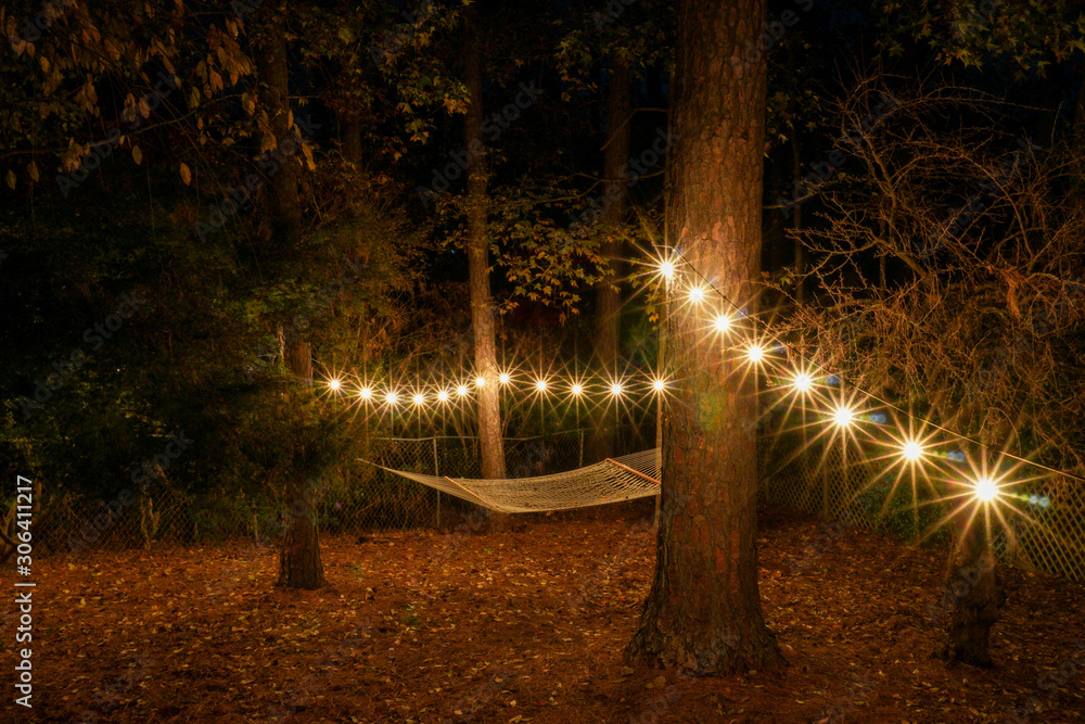 Back yard in the evening with a hammock and cafe lights strung up; starbursts; restful romantic evening