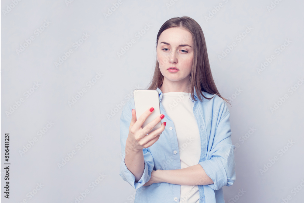 Attractive woman read the SMS in his smartphone, white background, copy space, toned Attractive woman read the SMS in his smartphone, white background, copy space, toned