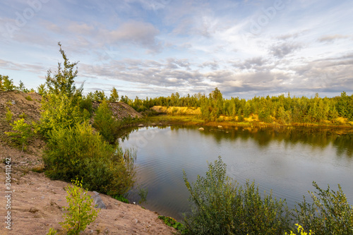 Sand steep shore and wood lake. Vast territories of Karelia in early autumn.