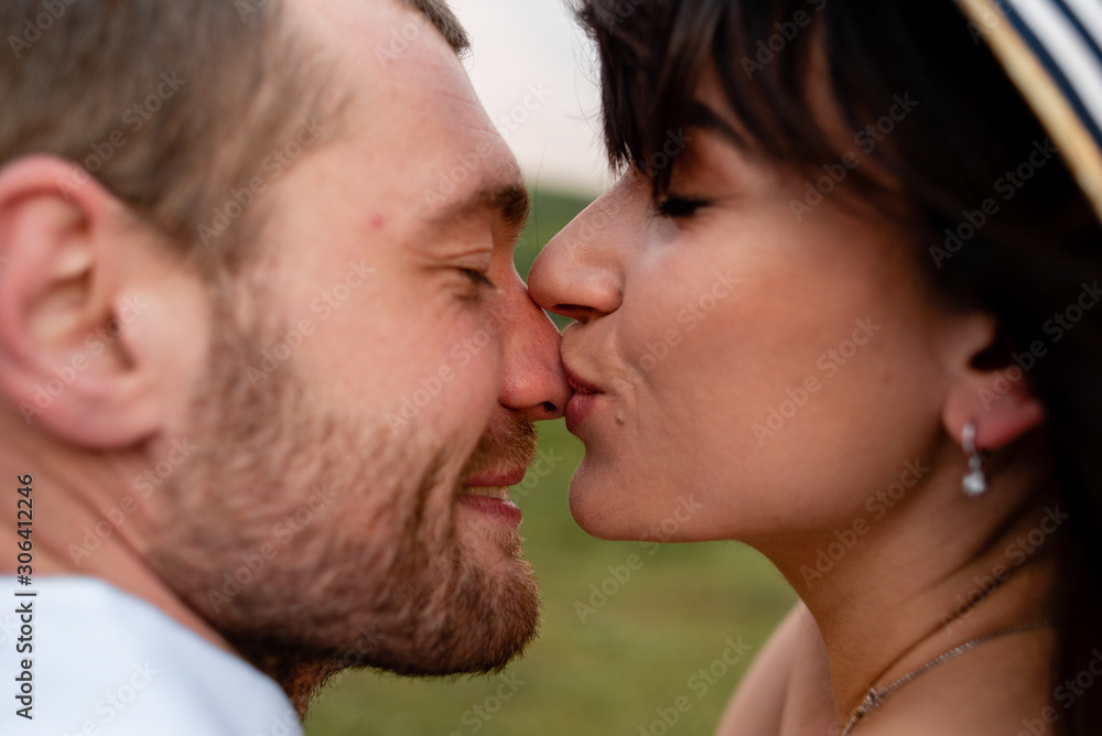 Girl kisses guy in the nose, a couple in love in nature Girl kisses guy in the nose, a couple in love in nature