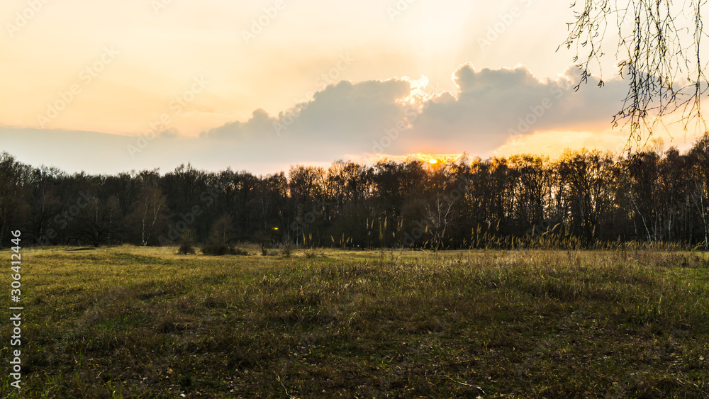 Winterlandschaft mit Wiesen und Wald bei Sonnenuntergang