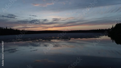 Drone flight over water and melting ice at sunset in Northwest Ontario, Canada.
