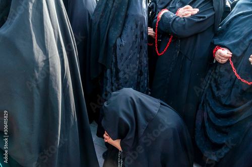 Ashura (asura or asure) ceremony in istanbul. Shiite women mourn for Husayn who killed in Battle of Karbala. Chained woman's hands in Ashura ceremony.