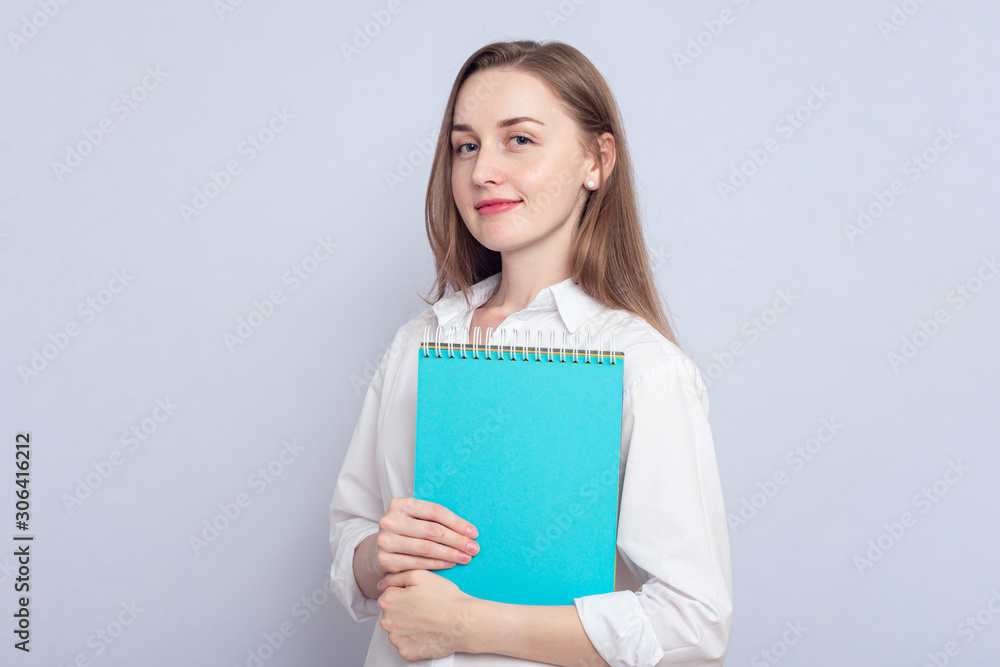 Girl student with notebooks. Concept of education. Portrait, grey background, copy space, slogan, toned Girl student with notebooks. Concept of education. Portrait, grey background, copy space, slogan, toned