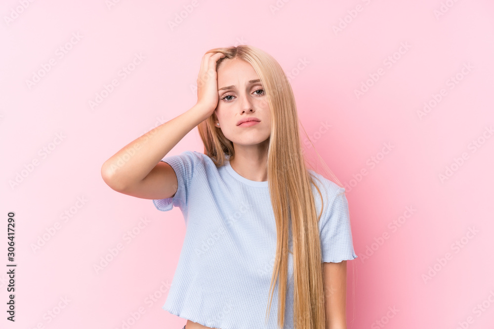 Young blonde woman on pink background tired and very sleepy keeping hand on head. Young blonde woman on pink background tired and very sleepy keeping hand on head.