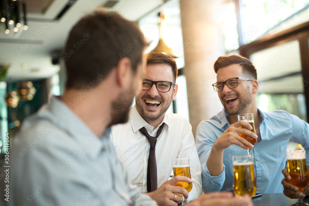 Funny conversation four businessmen while sit pub and drinking beer after work Funny conversation four businessmen while sit pub and drinking beer after work