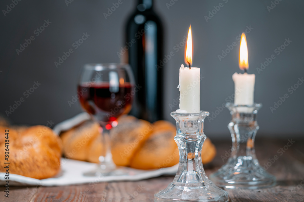 Shabbat Shalom. Challah bread, shabbat wine and candles on wooden table.