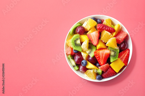 Fresh fruit salad on pink background