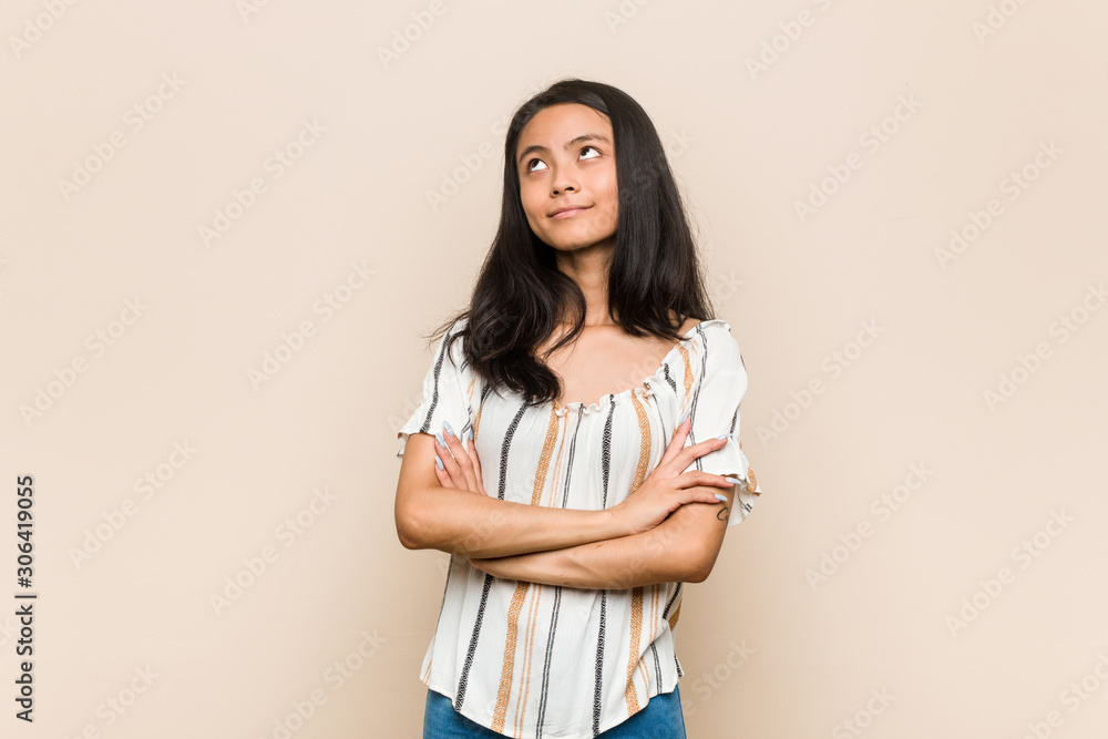 Fototapeta premium Young cute chinese teenager Young blonde woman wearing a coat against a pink background tired of a repetitive task.