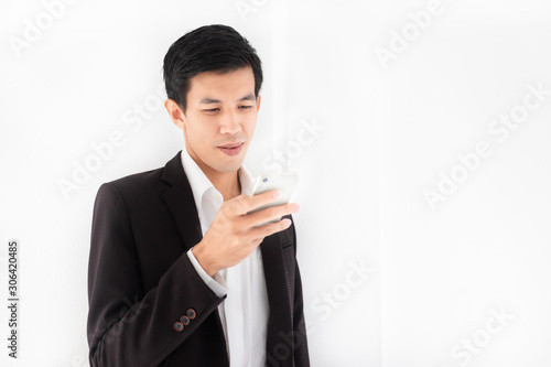 smart asian man holding smartphone and playing chat application, internet and communication technology photo