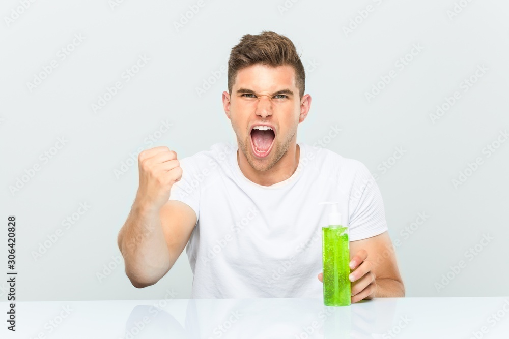 Young handsome man holding a aloe vera bottle cheering carefree and excited. Victory concept. Young handsome man holding a aloe vera bottle cheering carefree and excited. Victory concept.