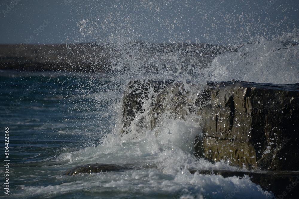 Naklejka premium Water Splash on Rocky Beach