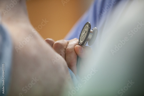 Obraz na plátne Close-up of doctor examining patient with stethoscope at hospital