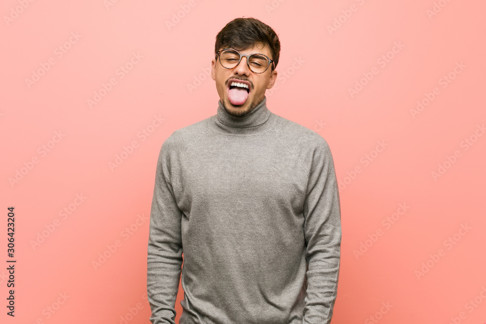 Young smart student man funny and friendly sticking out tongue. Young smart student man funny and friendly sticking out tongue.